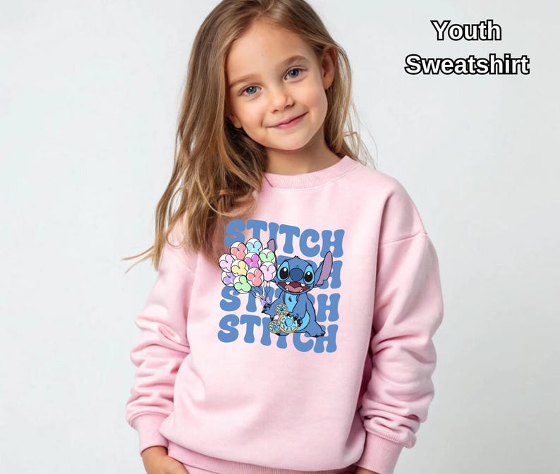 May include: Pink youth sweatshirt featuring a blue Stitch character holding colorful balloons with the word "Stitch" repeated in a retro font.