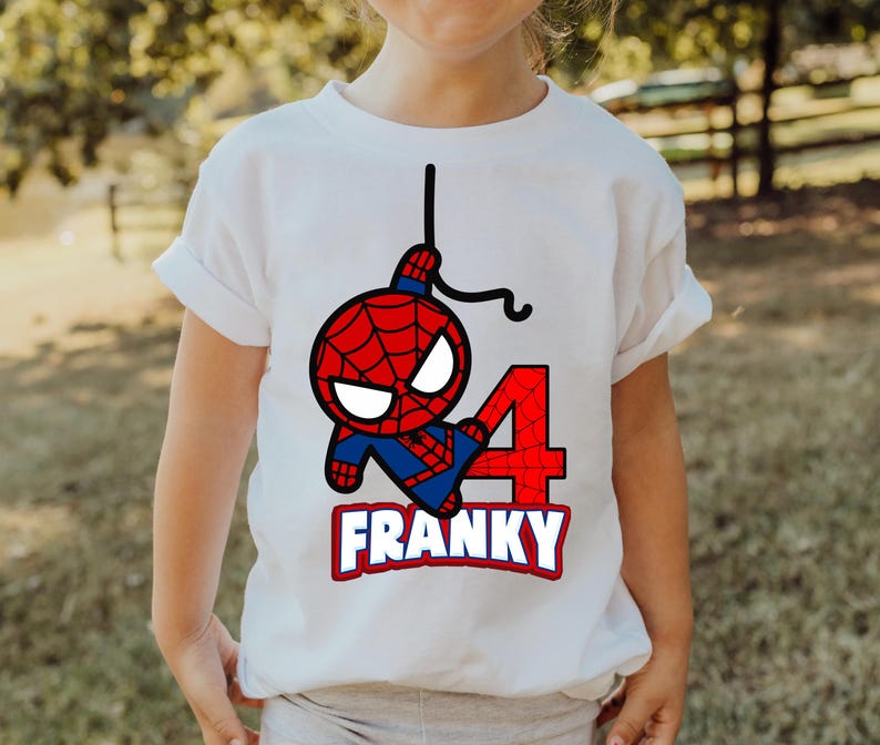 Puede incluir: Camiseta blanca con una imagen de dibujos animados de Spiderman colgando de una telara&ntilde;a, un n&uacute;mero 4 rojo y el nombre "FRANKY" impreso en la parte delantera.