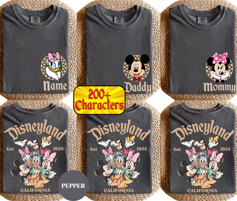 May include: Six gray t-shirts with Disney character designs. Three shirts have character faces with names like "Name", "Daddy", and "Mommy". The other three shirts say "Disneyland Est 1955 California" with character graphics.