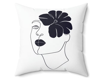May include: White throw pillow with a black line drawing of a face with a flower covering one eye.