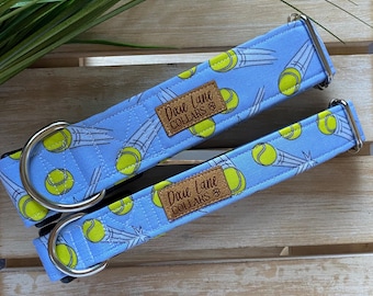 May include: Two blue dog collars with a tennis ball pattern and the text "Dixie Lane Collars" on each. The collars are made of fabric and have silver metal hardware.