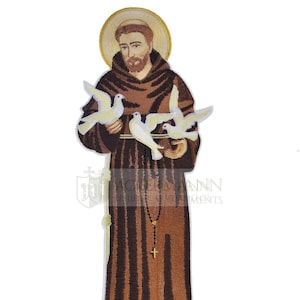 以下が含まれることがあります： 聖フランシスコ・アッシジの刺繍パッチ。白い鳩を3羽抱えています。茶色のローブを着て、金のロザリオと十字架を身につけています。パッチには、頭上に金の輪が描かれています。