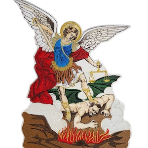 以下が含まれることがあります： 金色の羽根と剣を持った天使が、緑色の悪魔の上に立っている刺繍パッチ。天使は青いチュニックと赤いマントを着ており、悪魔は炎のベッドの上に横たわっています。