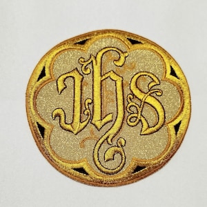以下が含まれることがあります： 金色の糸で刺繍された、IHSの文字が入った円形のパッチ。文字は装飾的な装飾が施され、明るい金色の背景に配置されています。パッチは黒のアクセントが付いたスカラップエッジで、装飾的なエンブレムを作成しています。