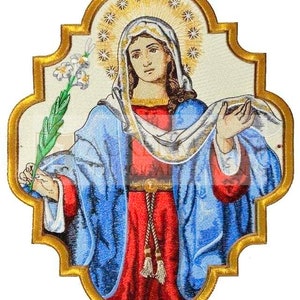 May include: Embroidered religious icon featuring a woman in a blue robe and red dress, holding a lily branch. The icon has a gold frame and a halo with star-like accents. The woman's face is serene, and the overall design is ornate.