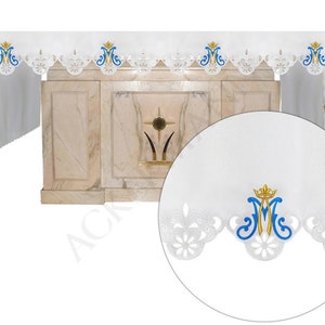 Peut inclure: Front d'autel blanc avec une bordure en dentelle et un "M" brodé en bleu et or avec une couronne. Le frontal est conçu pour un autel d'église.
