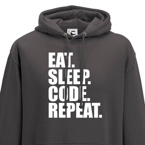 May include: A dark grey hooded sweatshirt with the text "EAT. SLEEP. CODE. REPEAT." printed in white on the front.