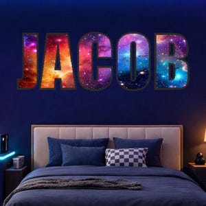 Könnte beinhalten: Ein modernes Schlafzimmer mit Gaming-Setup und Bett. Der Raum wird von Neonlichtern in Blau, Lila und Orange beleuchtet. Der Name "JACOB" ist in farbenfrohen Buchstaben im Galaxiestil an der Wand zu sehen. Ein Neon-Blitz-Schild ist ebenfalls vorhanden.