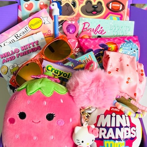 May include: A collection of children's toys and accessories including a pink strawberry plush, orange sunglasses, a Zuru Mini Brands ball, a Hello Kitty keychain, a Barbie coloring book, a pen with a unicorn topper, stickers, and a pink cherry-print fabric.