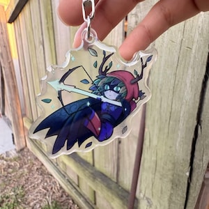 May include: A set of three ceramic mugs with a speckled, cream-colored glaze. Each mug features a different hand-painted floral design in shades of blue, green, and yellow. The mugs have a simple, rounded shape and a comfortable handle.