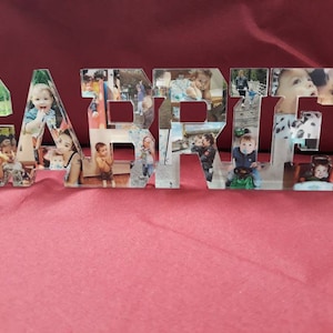 Può includere: Un nome in resina trasparente, "GARRETT", con ogni lettera riempita con varie foto. Le foto sembrano essere di un bambino piccolo. Il nome è visualizzato su una superficie rossa.
