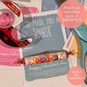 May include: A blue and white printable Valentine's Day card with the text "God made you a Smartie" and a small pack of Smarties sweets. The card also includes the text "For the Lord gives wisdom; from his mouth come knowledge and understanding. Proverbs 2:6".