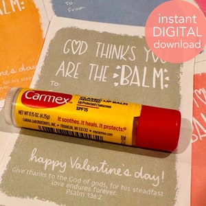 May include: A Valentine's Day card with the text "God thinks you are the balm" and a tube of Carmex lip balm. The card is light brown with white text and the lip balm is yellow and red.