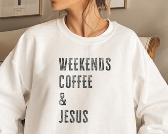 Op de afbeelding: Wit unisex sweatshirt met de tekst "Weekends Coffee & Jesus" bedrukt op de voorkant. Het sweatshirt is gemaakt door Gildan en is een zware mix.