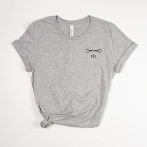 May include: A gray t-shirt with a black equestrian bit and the letters "ECL" printed on the front.