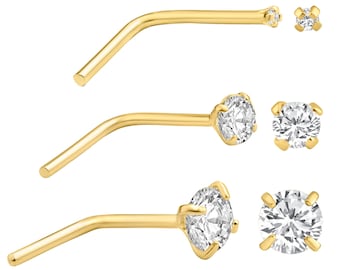 May include: Three gold nose rings with clear cubic zirconia stones. The stones are different sizes and shapes. The rings are curved to fit the nose.