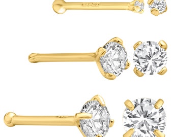 May include: Three gold nose rings with a clear round gemstone. The rings are shown in different positions to show the detail of the gemstone.