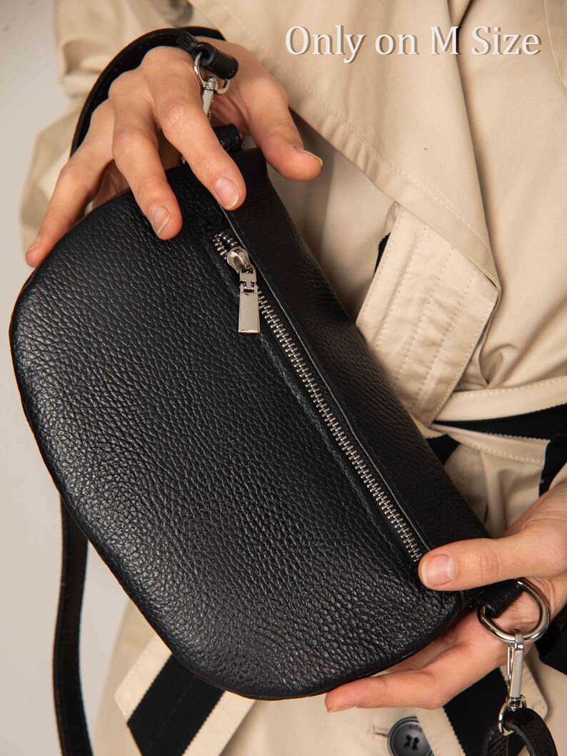 a person is holding a black purse