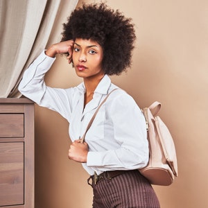 a woman with an afro holding a purse