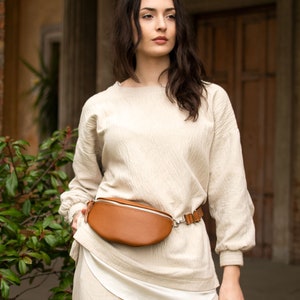 a woman wearing a tan belt bag