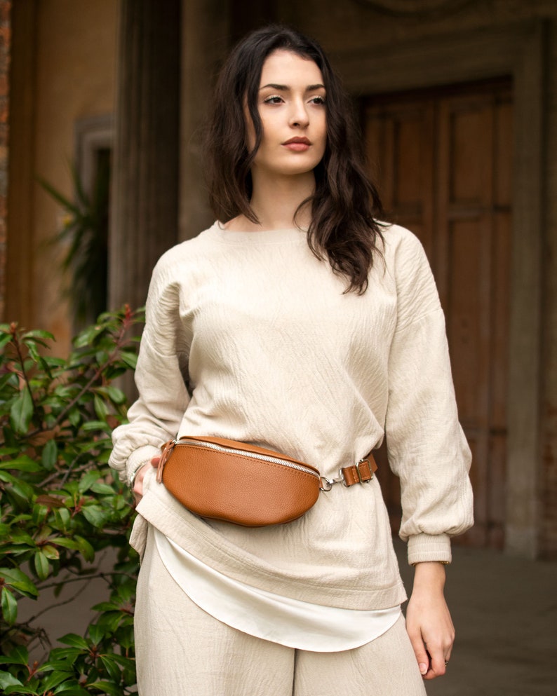 a woman wearing a tan belt bag