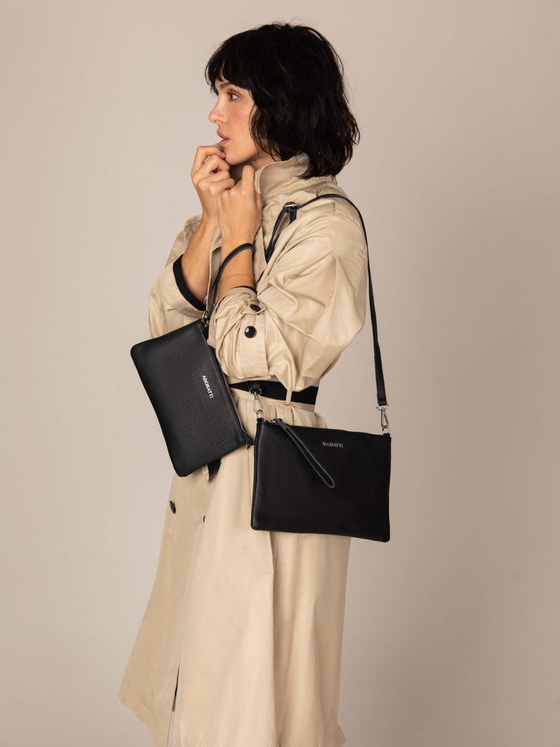 a woman in a trench coat holding a black purse