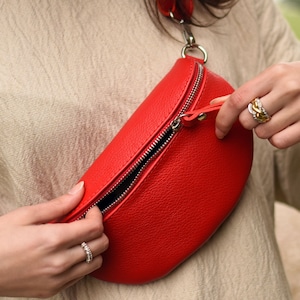 a woman holding a red purse in her hands