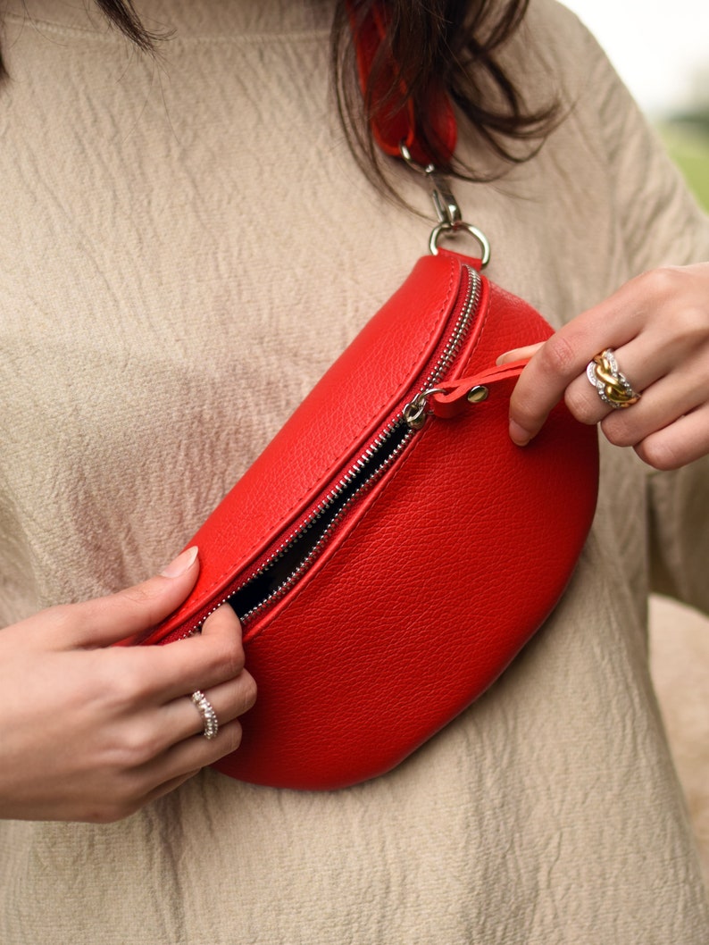 a woman holding a red purse in her hands