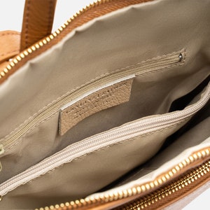 a brown purse with a zipper on the inside of it