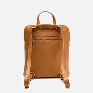 a tan leather backpack on a white background