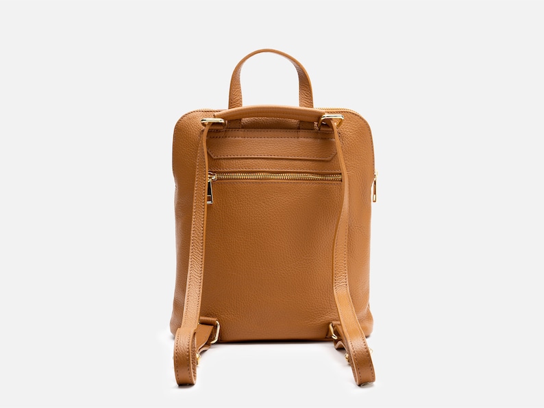 a tan leather backpack on a white background