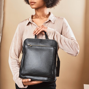 a woman holding a black briefcase in her hands