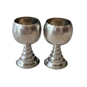 May include: A white ceramic mug with a black handle and the text "But First, Coffee" in a bold, black font. The mug is on a wooden surface. The mug is 10 cm tall.