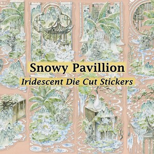 May include: A set of iridescent die-cut stickers with a snowy pavilion design. The stickers depict detailed illustrations of pagodas, mountains, and water features in green, white, and blue, set against a peach backdrop. The text "Snowy Pavilion" and "Iridescent Die Cut Stickers" are visible.