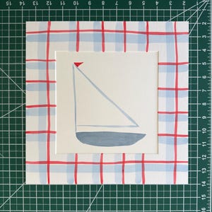 May include: A square painting on paper featuring a centered sailboat illustration with a grey hull, light blue sail, and small red flag. The border is decorated with a hand-painted red and light blue plaid pattern. The artwork measures 10 inches.