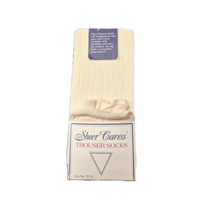 May include: A package of off-white Sheer Caress trouser socks. The packaging includes text that reads "These Trouser Socks will complement your pants and trouser wardrobe with durability and style. For comfort, the top band is generously proportioned."