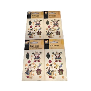 May include: Four packages of "Rub-ons" transfers featuring Christmas-themed designs. Each package displays a Santa Claus illustration, along with stockings, gifts, and stars. The packages have a yellow and black color scheme.