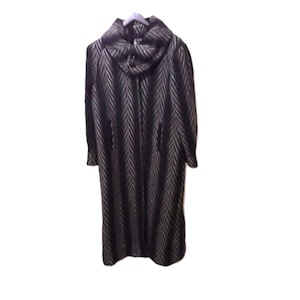 May include: A long, dark grey coat with a chevron pattern. The coat features a large, cowl-style collar and is hanging on a light grey hanger. The coat has long sleeves and a full length design.