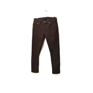 May include: Dark brown denim jeans hanging on a white hanger. The jeans have a classic five-pocket design with a button and zip closure. The trousers are a solid colour and appear to be made of a durable material.