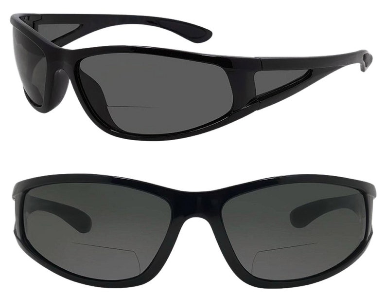 May include: Black sunglasses with a dark gray lens and a clear reading lens attached to the bottom of the frame.