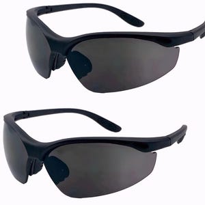 May include: Two pairs of black safety glasses with gray lenses. The glasses have a wraparound design and are made of a durable plastic.