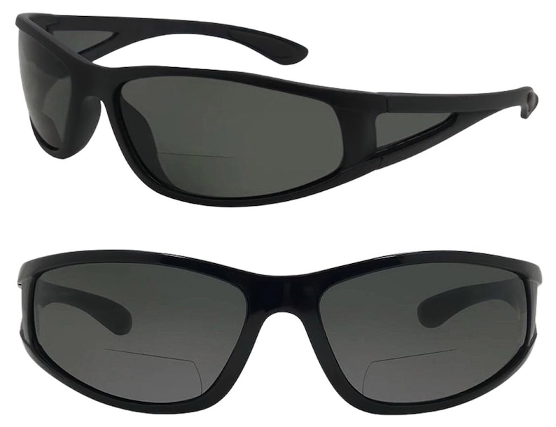 May include: Black sunglasses with a dark gray lens and a clear reading lens on the bottom. The sunglasses have a curved frame and a black plastic frame.