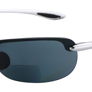 May include: Silver-framed sunglasses with dark gray lenses. The sunglasses have a clip-on feature for reading glasses.