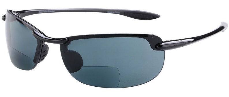 May include: Black sunglasses with a dark gray lens and a clip-on reading lens. The sunglasses have a black frame and a black temple.