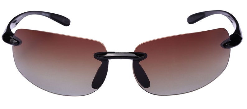 May include: Black sunglasses with a brown gradient lens. The sunglasses have a rimless design and a sleek, modern look.