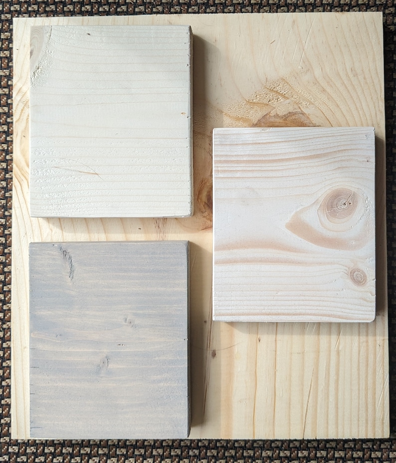 May include: Three wood samples, one is a light natural wood, one is a light gray wood, and one is a white wood.