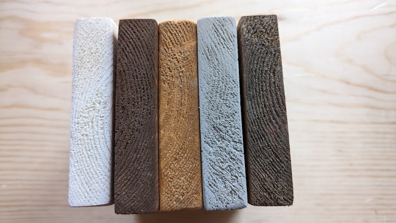 May include: Five wooden boards, each painted a different color: white, dark brown, light brown, light blue, and dark gray.
