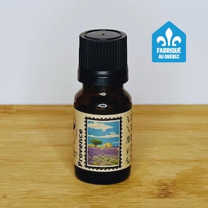 May include: A small brown glass bottle with a black cap, filled with essential oil. The label features a vintage-style stamp with a lavender field and the word "Provence". The bottle is labelled "Fabriqué au Québec".