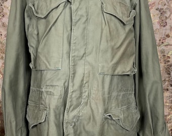 May include: A vintage green military jacket with multiple pockets and a button closure.