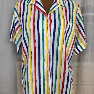 May include: A white button-down shirt with colorful vertical stripes in red, blue, green, and yellow.